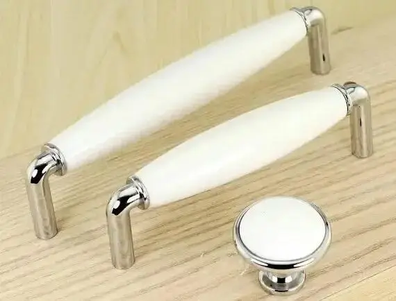 Close-up of a modern handle on a white kitchen cabinet.