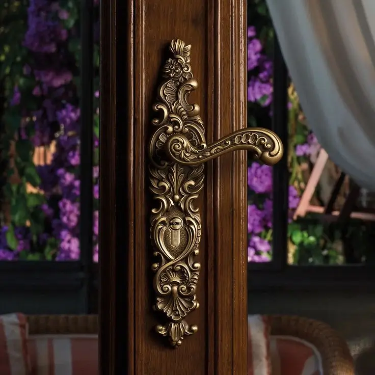 An ornate, classic brass handle on a dark wood door.