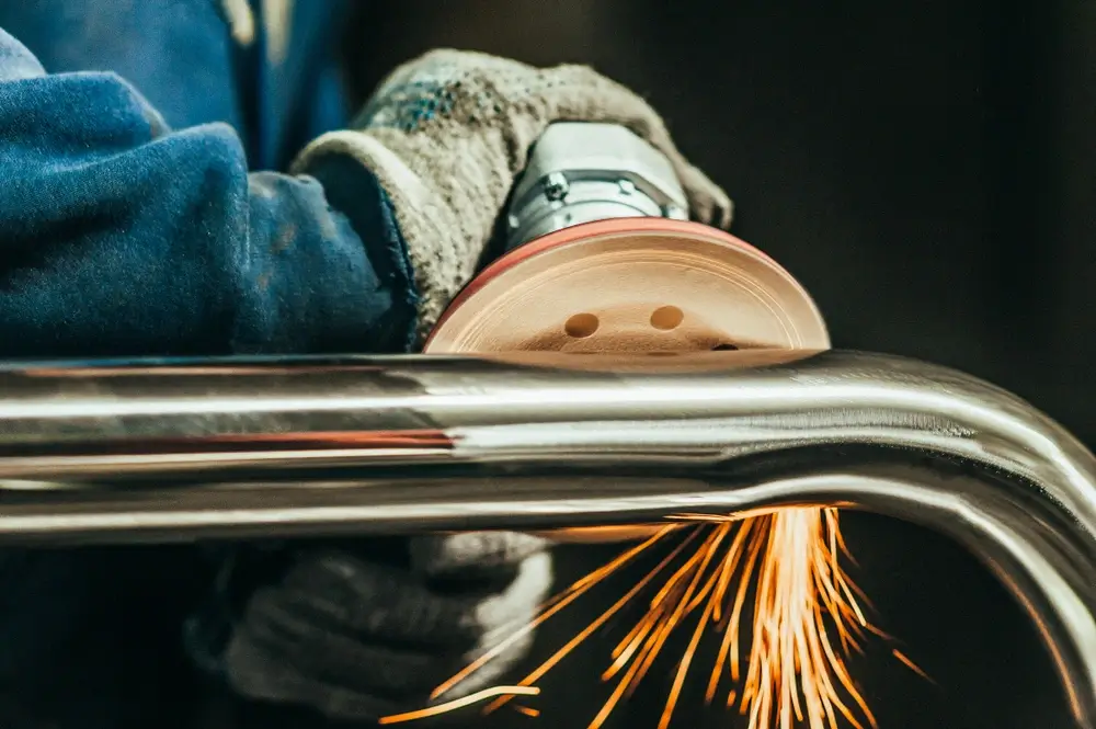 Close-up detail of polishing a metal piece.