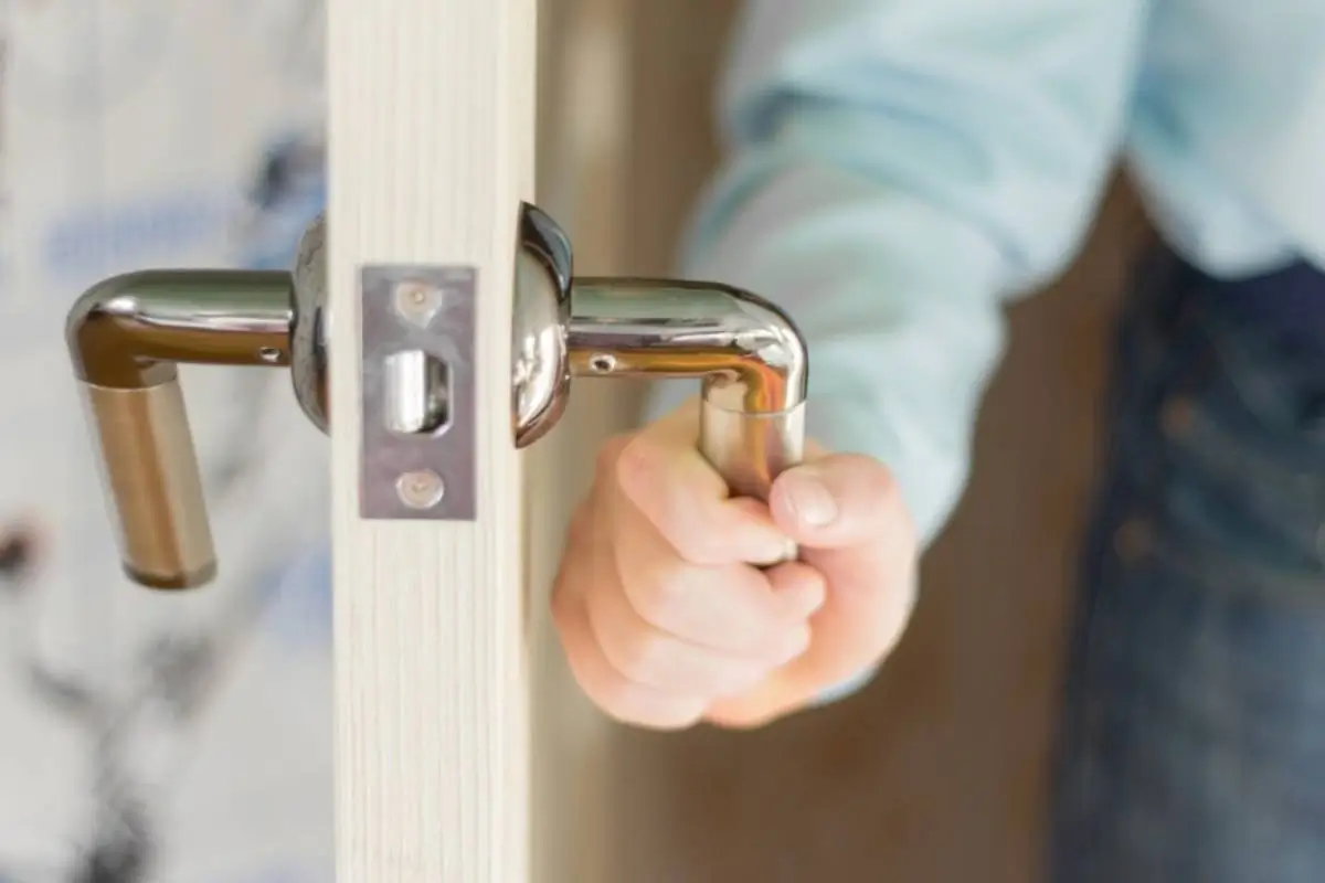 Hands of a craftsman holding a metal hardware piece.